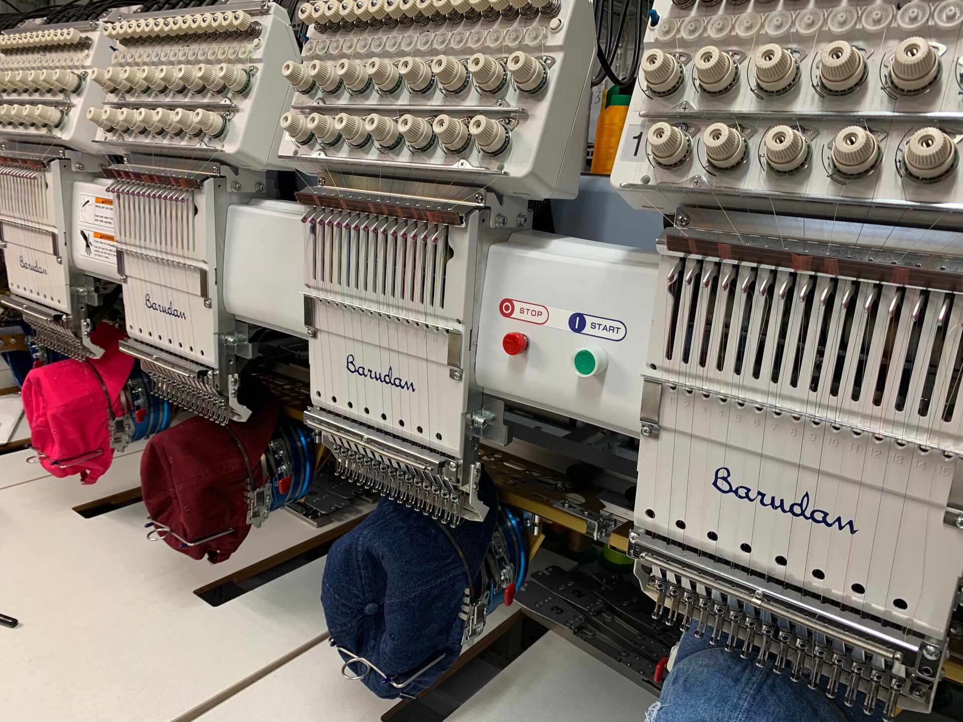 Multi-head commercial embroidery machines stitching custom caps in our studio