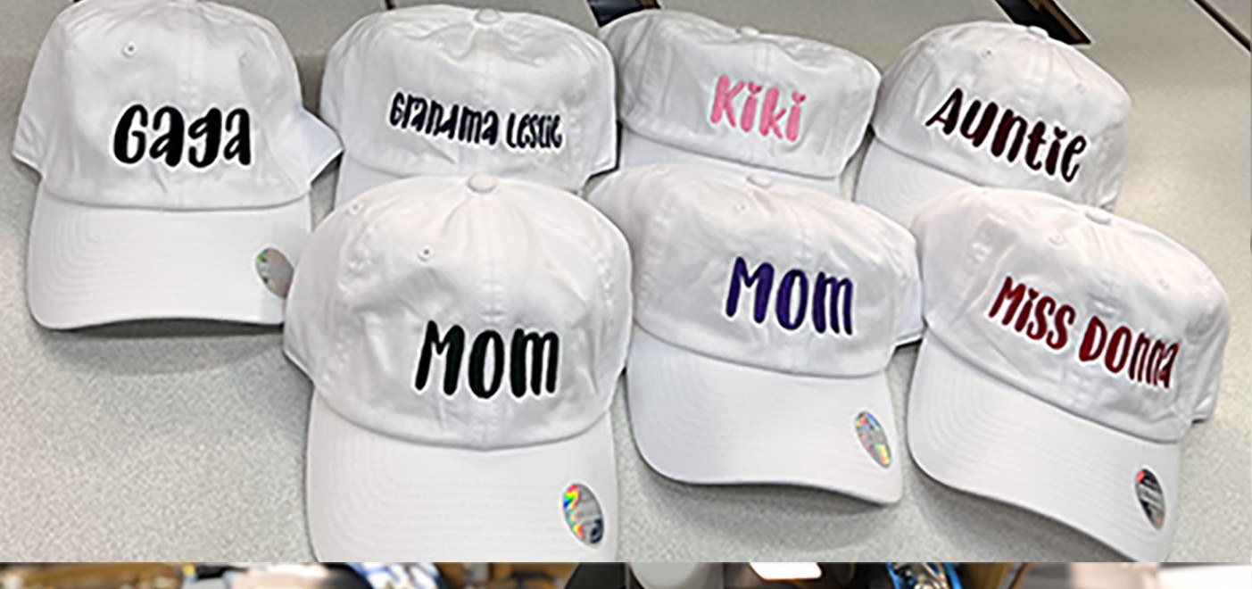 Personalised white caps with embroidered names, stitched in-house