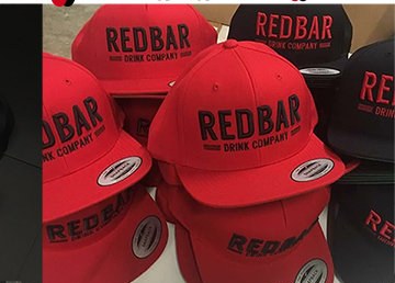 Bulk run of red snapbacks embroidered for Redbar Drink Company